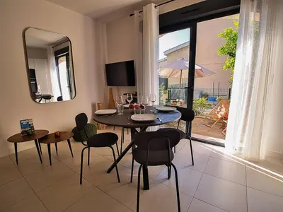 a dining room with a table and chairs and a window at Duplex Cosy- Sérénité en Bord de Mer in Borgo