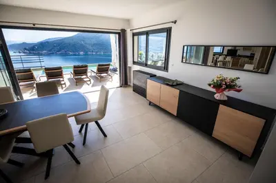 a room with a table and chairs and a large window at Villa d'architecte classée 5 étoiles in Campomoro