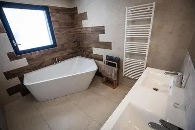 a bathroom with a large white tub and a window at Villa d'architecte classée 5 étoiles in Campomoro
