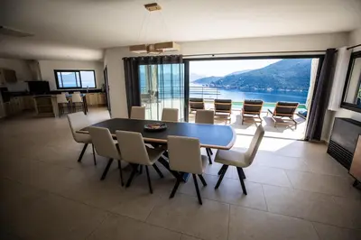 a dining room with a table and chairs with a view at Villa d'architecte classée 5 étoiles in Campomoro