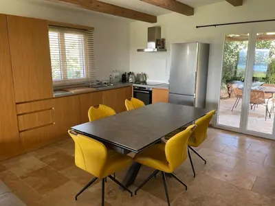 a kitchen with a dining table and yellow chairs at Loue Villa Bonifacio vue mer in Bonifacio