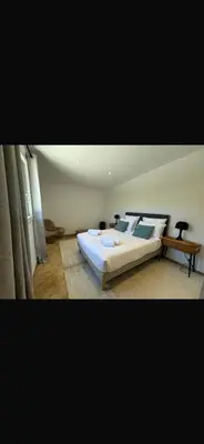 a bedroom with a large bed and a table at Loue Villa Bonifacio vue mer in Bonifacio
