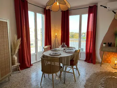 a dining room with red curtains and a table with chairs at Casa Lucia in Aléria