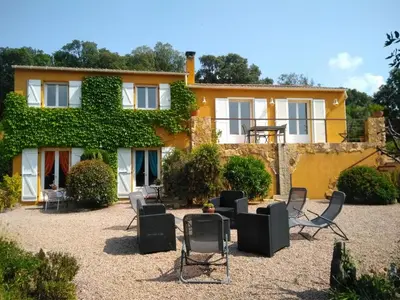 a house with chairs in front of it at Chez Nat et JC in Eccica-Suarella