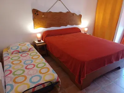 a bedroom with a bed and two lamps on two tables at Chez Nat et JC in Eccica-Suarella