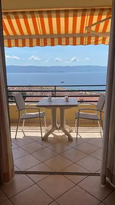 a table and two chairs on a balcony with the ocean at Le petit paradis avec vue mer in Ajaccio
