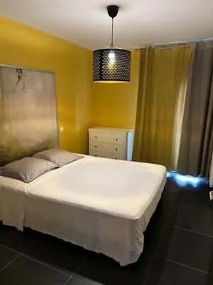 a bedroom with a white bed and a yellow wall at Ajaccio j2 in Ajaccio