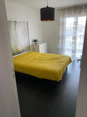 a bedroom with a yellow bed and a window at Ajaccio j2 in Ajaccio