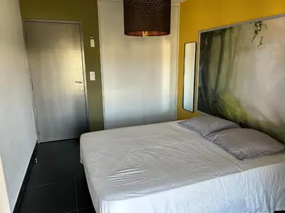a bedroom with a bed with a large painting on the wall at Ajaccio j2 in Ajaccio