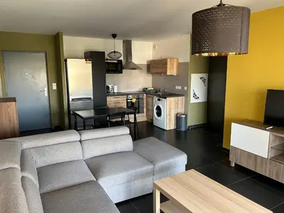 a living room with a couch and a kitchen at Ajaccio j2 in Ajaccio