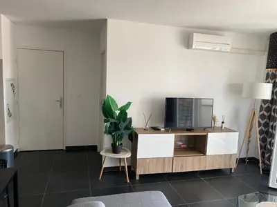 a living room with a tv on a wooden cabinet at Ajaccio j2 in Ajaccio