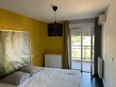 a bedroom with a bed and a yellow wall at Ajaccio j2 in Ajaccio
