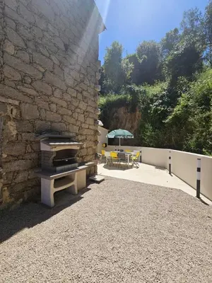 a table with a green umbrella and yellow chairs at Maison Fernand & Marie Claire in Coti-Chiavari