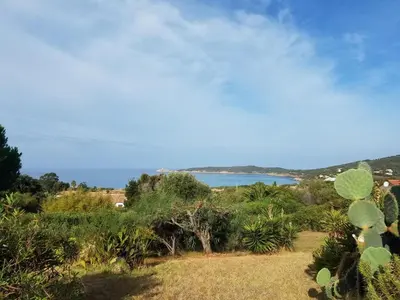 a view of a body of water from a field at Beau logement de type F3 avec jardin fleuri à 5 min de la plage in Cargèse