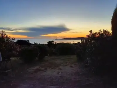 a view of the ocean at sunset at Beau logement de type F3 avec jardin fleuri à 5 min de la plage in Cargèse