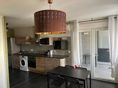 a kitchen with a dining table and aendant light at Ajaccio j1 in Ajaccio