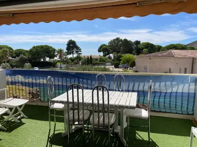 a table and chairs on a balcony with a view of the water at Le Cosy Corse in Vico