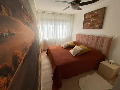a bedroom with a bed and a painting on the wall at Le Cosy Corse in Vico