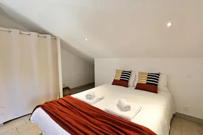 a bedroom with a white bed with two pillows at Casa di Lilla - Escapade dans une maison de charme in San-Gavino-di-Carbini