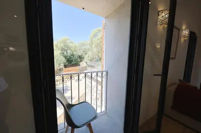 a chair sitting on a balcony looking out a window at Casa di Lilla - Escapade dans une maison de charme in San-Gavino-di-Carbini