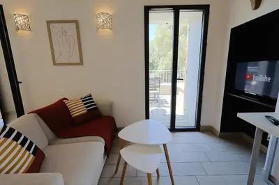 a living room with a couch and a tv at Casa di Lilla - Escapade dans une maison de charme in San-Gavino-di-Carbini