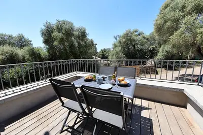 a table and two chairs on a deck with a table and chairs at Casa di Lilla - Escapade dans une maison de charme in San-Gavino-di-Carbini