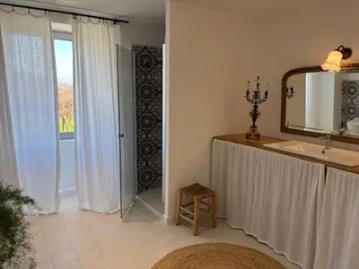 a bathroom with a sink and a mirror and a window at La demeure des vignes in Murato