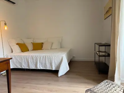 a white bed with yellow pillows in a room at La demeure des vignes in Murato