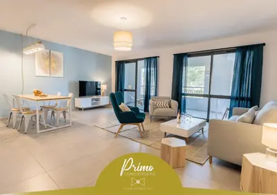 a living room with a couch and a table at Le Nathalia - T3 4 étoiles, vue port de Bonifacio in Bonifacio