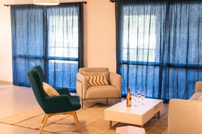 a living room with two chairs and a coffee table at Le Nathalia - T3 4 étoiles, vue port de Bonifacio in Bonifacio