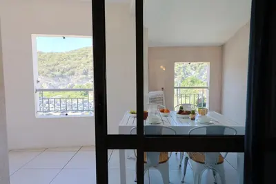 a dining room with a table and a window at Le Nathalia - T3 4 étoiles, vue port de Bonifacio in Bonifacio