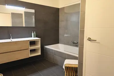 a bathroom with a tub and a sink and a toilet at Le Nathalia - T3 4 étoiles, vue port de Bonifacio in Bonifacio