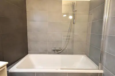 a bathroom with a tub and a shower at Le Nathalia - T3 4 étoiles, vue port de Bonifacio in Bonifacio