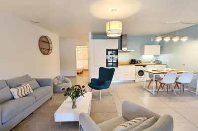 a living room and kitchen with a couch and a table at Le Nathalia - T3 4 étoiles, vue port de Bonifacio in Bonifacio