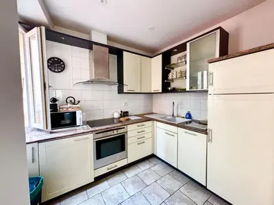 a kitchen with white cabinets and white appliances at Casamea - Vieille Ville, 2 min plage, Clim in Ajaccio