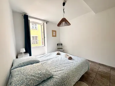 a bedroom with a bed with a stuffed animal on it at Casamea - Vieille Ville, 2 min plage, Clim in Ajaccio