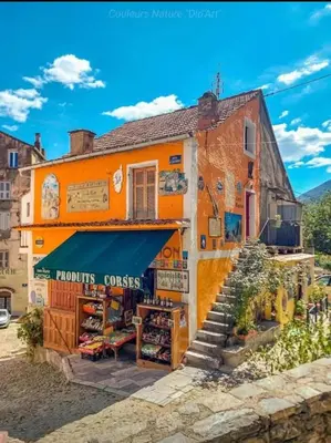 an orange building with a store in front of it at T2 climatisé, pour 2 à 4 pers, à 5mn plage à pied in San-Nicolao