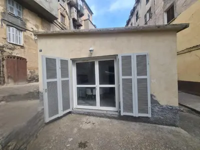 a building with white doors in a street at appartement indépendant CORTE in Corte