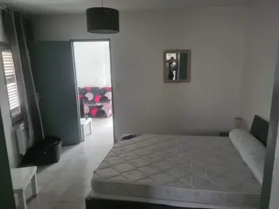 a bedroom with a bed and a door into a room at appartement indépendant CORTE in Corte