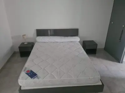 a bed in a room with two tables and a mattress at appartement indépendant CORTE in Corte