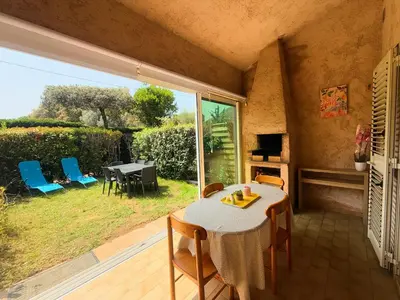 a dining room with a table and chairs and a window at La Dolce Villa avec Piscine in Zonza