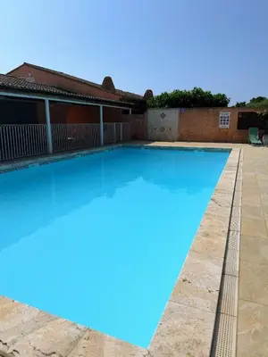 a swimming pool with blue water in front of a house at La Dolce Villa avec Piscine in Zonza
