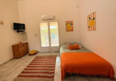 a bedroom with a bed and a dresser and a television at La Dolce Villa avec Piscine in Zonza