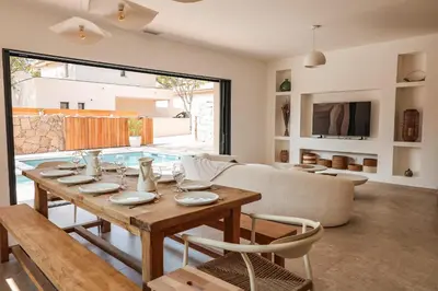 a dining room with a table and a couch at Villa Luciana Di Santa Lucia in Sainte-Lucie de Porto-Vecchio