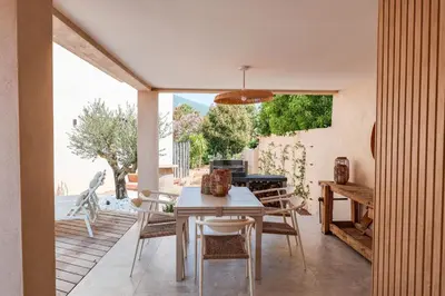 a dining room with a table and chairs on a patio at Villa Luciana Di Santa Lucia in Sainte-Lucie de Porto-Vecchio