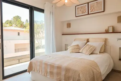 a bedroom with a bed and a large window at Villa Luciana Di Santa Lucia in Sainte-Lucie de Porto-Vecchio