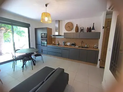 a kitchen with a table and a dining room at havre de paix au bord de mer - Casa Marina in Borgo