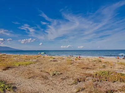 a group of people on a beach near the ocean at havre de paix au bord de mer - Casa Marina in Borgo
