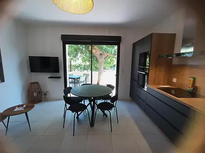 a kitchen with a table and chairs in a room at havre de paix au bord de mer - Casa Marina in Borgo