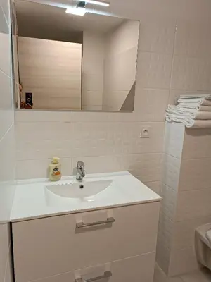 a white bathroom with a sink and a mirror at havre de paix au bord de mer - Casa Marina in Borgo